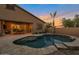 Relax in this backyard featuring a beautiful pool, palm trees, and a covered patio for outdoor enjoyment at 3907 E Carob Dr, Gilbert, AZ 85298