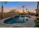 The spacious backyard boasts a sparkling pool, lush landscaping, and inviting seating areas for outdoor relaxation at 3907 E Carob Dr, Gilbert, AZ 85298