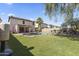 Large backyard with pool, rock features, palm tree, and lush lawn at 45722 W Barbara Ln, Maricopa, AZ 85139