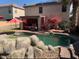 Inviting backyard with a refreshing pool, covered patio, and lush landscaping at 45722 W Barbara Ln, Maricopa, AZ 85139