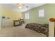 Spacious bedroom with bright yellow walls, ceiling fan, and a foosball table at 45722 W Barbara Ln, Maricopa, AZ 85139