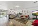 Spacious living room with wood floors, modern decor, and large windows at 45722 W Barbara Ln, Maricopa, AZ 85139