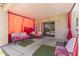 Covered outdoor patio with comfortable seating and bright pink accents at 45722 W Barbara Ln, Maricopa, AZ 85139