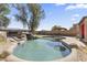 Backyard pool featuring stone waterfall and desert landscaping at 45722 W Barbara Ln, Maricopa, AZ 85139
