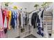 Well-organized walk-in closet with hanging clothes, built-in shelving, and ample storage space at 45722 W Barbara Ln, Maricopa, AZ 85139