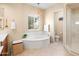 Elegant bathroom featuring a soaking tub, chandelier, and separate shower area at 4614 E Reins Rd, Gilbert, AZ 85297