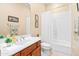 Bright bathroom featuring a shower with tub, cherry vanity, white countertops and tile floors at 4614 E Reins Rd, Gilbert, AZ 85297