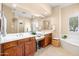 Luxurious bathroom with double vanities, a large mirror, and a separate soaking tub at 4614 E Reins Rd, Gilbert, AZ 85297