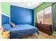 Bedroom with blue accent wall, carpeted floors, a double dresser and lots of natural light at 4614 E Reins Rd, Gilbert, AZ 85297