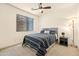 Neutral bedroom with a striped comforter, carpeted floors, a side table and natural lighting at 4614 E Reins Rd, Gilbert, AZ 85297