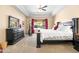 Comfortable bedroom featuring a tray ceiling, large window, and neutral decor at 4614 E Reins Rd, Gilbert, AZ 85297