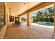 Spacious covered patio with outdoor dining set, offering a seamless transition to the beautiful backyard and pool area at 4614 E Reins Rd, Gilbert, AZ 85297