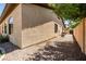 Side exterior of home showing neutral stucco, windows, and gravel landscaping at 4614 E Reins Rd, Gilbert, AZ 85297