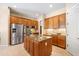 Open kitchen boasts stainless steel appliances, granite countertops, wood cabinets, tile floors, and kitchen island at 4614 E Reins Rd, Gilbert, AZ 85297