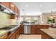 Gourmet kitchen with granite countertops, tile backsplash, stainless steel appliances, and view into living space at 4614 E Reins Rd, Gilbert, AZ 85297