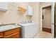 Bright laundry room features a white washer and dryer, storage cabinets and tile flooring at 4614 E Reins Rd, Gilbert, AZ 85297