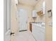 Bright laundry room features a white washer and dryer, storage cabinets and tile flooring at 4614 E Reins Rd, Gilbert, AZ 85297