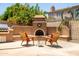 Outdoor living space featuring a custom BBQ and fireplace, creating a cozy and inviting atmosphere for entertaining at 4614 E Reins Rd, Gilbert, AZ 85297