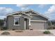 Charming single-story home with a two-car garage, desert landscaping and stone column at 47705 W Kenner Dr, Maricopa, AZ 85139