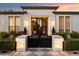 Elegant front entrance with an ornate black gate and black framed glass doors at 5700 E Sanna St, Paradise Valley, AZ 85253