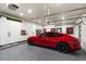 Spacious garage featuring a sleek red car, built-in storage cabinets, and ample space for multiple vehicles at 5700 E Sanna St, Paradise Valley, AZ 85253