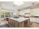 Gourmet kitchen with a large island, white cabinets, and stainless steel appliances, adjacent to an eat-in dining area at 5700 E Sanna St, Paradise Valley, AZ 85253