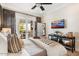 Cozy bedroom features French doors leading to a patio, complemented by a ceiling fan and mounted TV at 5700 E Sanna St, Paradise Valley, AZ 85253