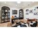 Well-lit home office featuring built-in shelves, a modern desk, and classic auto racing photos at 5700 E Sanna St, Paradise Valley, AZ 85253