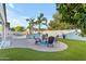 Landscaped backyard featuring palm trees, an outdoor fire pit, and a pool with built-in water features at 5941 S Cambridge St, Chandler, AZ 85249