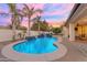 Inviting backyard pool with a built-in waterfall feature and palm trees, perfect for relaxation at 5941 S Cambridge St, Chandler, AZ 85249