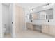 Bright bathroom featuring double sinks, quartz countertop, and tall storage cabinet at 641 W Oriole Way, Chandler, AZ 85286