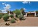 Charming home with desert landscaping, brick driveway, and terra cotta roof tiles under a beautiful blue sky at 8934 E Rusty Spur Pl, Scottsdale, AZ 85255