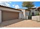 Spacious two-car garage with a brick driveway, terra cotta roof, and secure gate at 8934 E Rusty Spur Pl, Scottsdale, AZ 85255