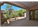 Covered outdoor patio with brick-paved floor, view of backyard with desert landscaping, and direct access to the house at 8934 E Rusty Spur Pl, Scottsdale, AZ 85255