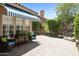 Inviting backyard patio with striped awning, comfortable seating, lush landscaping, and a charming water feature at 9280 E Davenport Dr, Scottsdale, AZ 85260