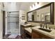 Bathroom featuring double sinks with granite countertops and a walk-in shower with glass door at 9280 E Davenport Dr, Scottsdale, AZ 85260
