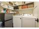 Efficient laundry area with modern washer, dryer, shelving, storage, and refrigerator for added convenience at 9280 E Davenport Dr, Scottsdale, AZ 85260
