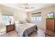 Bright bedroom with a queen-size bed, lamps, and blinds on the windows at , Mesa, AZ 85201