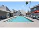 Community pool with lounge chairs, palm trees, and several apartment units at , Mesa, AZ 85201