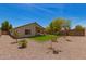 View of home's backyard with grass, gravel, and block wall fence at 10212 E Caballero St, Mesa, AZ 85207