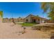 View of home's backyard with gravel, grass, and block wall fence at 10212 E Caballero St, Mesa, AZ 85207