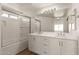 Bright bathroom with dual vanity sinks, quartz countertop and shower over tub combination at 10212 E Caballero St, Mesa, AZ 85207
