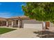 Inviting single-story home with lush green lawn, a two-car garage, and a charming covered porch at 10212 E Caballero St, Mesa, AZ 85207