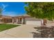 Inviting single-story home with lush green lawn, a two-car garage, and a charming covered porch at 10212 E Caballero St, Mesa, AZ 85207