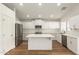 Modern kitchen with stainless steel appliances, white cabinets, and a large island at 10212 E Caballero St, Mesa, AZ 85207