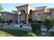 Charming single-story home features an arched entryway, tiled roof, desert landscaping, and lush green grass at 11290 N 117Th St, Scottsdale, AZ 85259