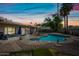 Resort-style backyard with a sparkling pool, lush landscaping, and covered patio area, perfect for entertaining at 14830 N 28Th Pl, Phoenix, AZ 85032