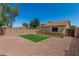 A fenced backyard with artificial turf surrounded by gravel and neighboring homes at 16160 W Custer Ln, Surprise, AZ 85379