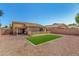 Wide view of the backyard with artificial turf surrounded by gravel and block fence at 16160 W Custer Ln, Surprise, AZ 85379