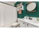 Charming bathroom with white vanity, round mirror, and a shower with a patterned curtain at 16160 W Custer Ln, Surprise, AZ 85379